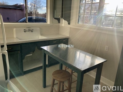 A kitchen with a table and a sink.