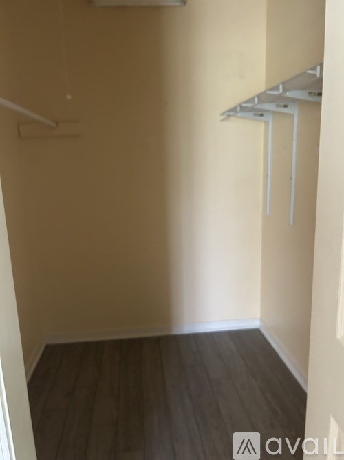A room with a white shelf and wooden flooring.
