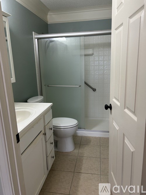 A bathroom with a toilet, sink, and shower.