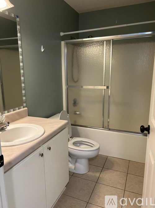 A bathroom with a toilet, sink, and shower.