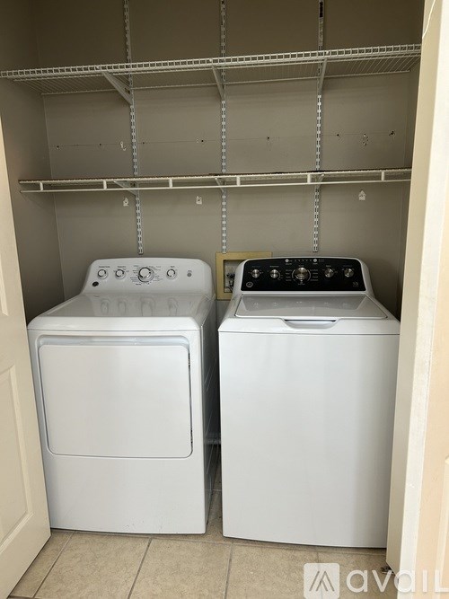 Two white front loading washing machines in a laundry room.
