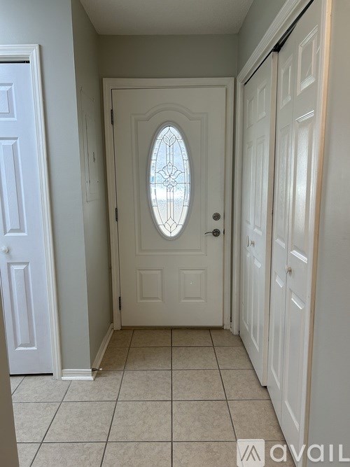 A white door with a glass window in the middle of a hallway.
