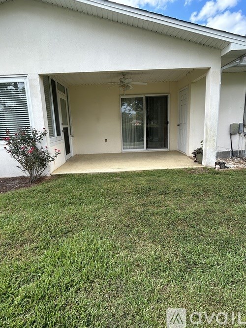 A white house with a green lawn in front.