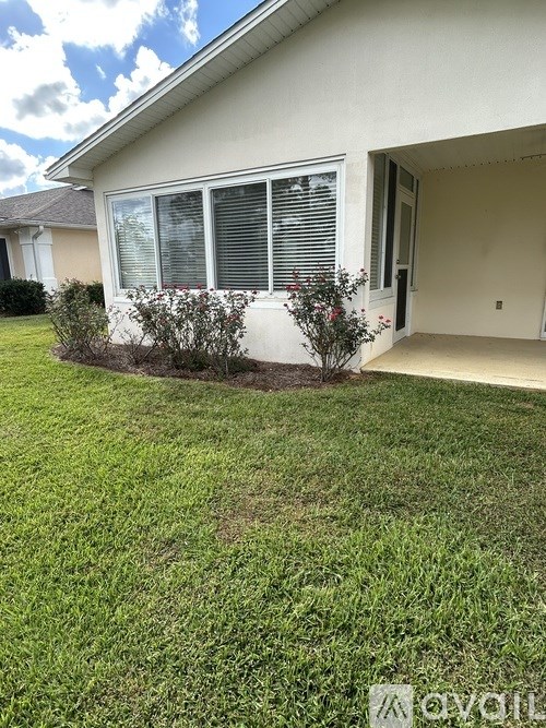 A house with a white exterior and a green lawn.