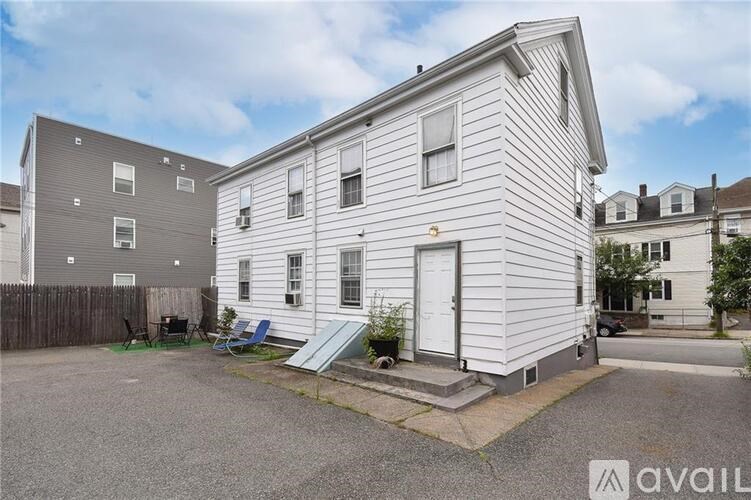 A two-story house with a white exterior and a small front yard.