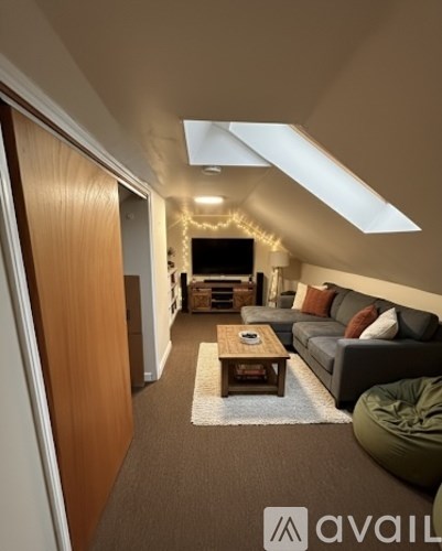A living room with a couch, coffee table, and a skylight.