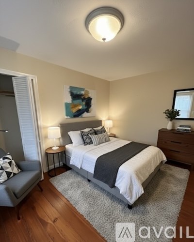 A bedroom with a bed, nightstand, and chair.