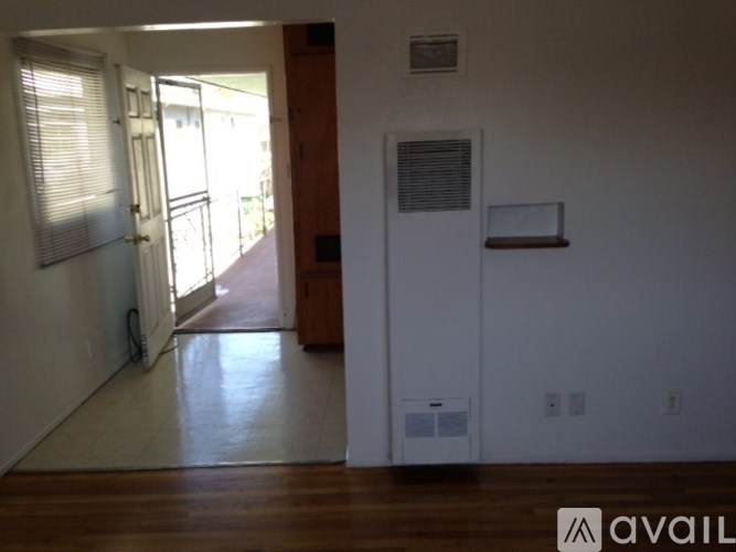 A room with a white door and a window with blinds.