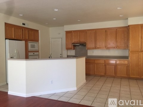 A kitchen with wooden cabinets and a white island.