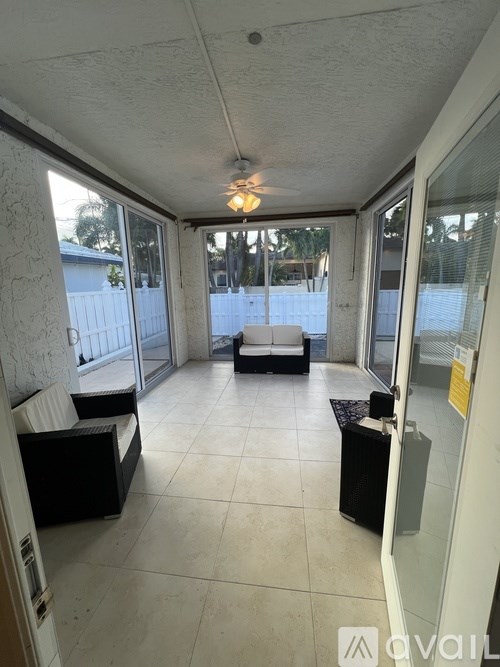 A room with a white ceiling and tiled floor with a bench and a table.