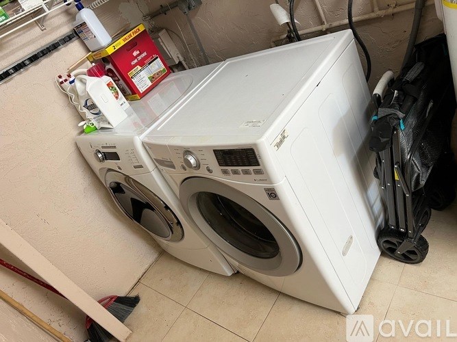 A white front load washing machine is in a laundry room.