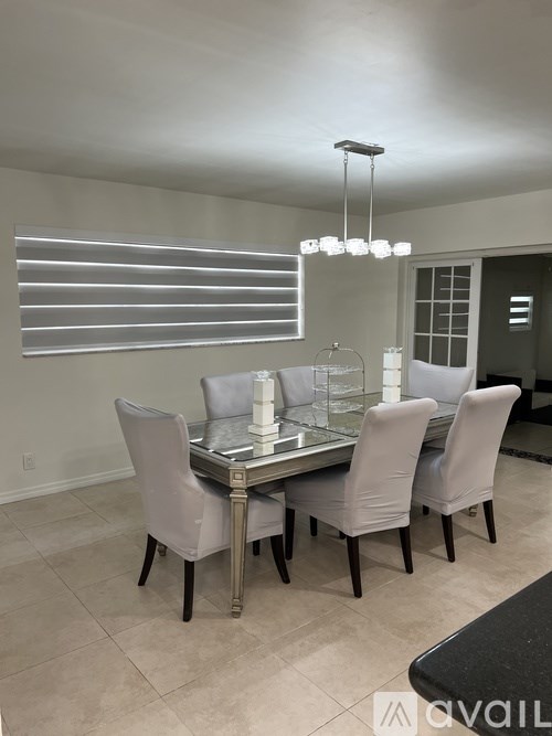 A dining room with a glass table and chairs.