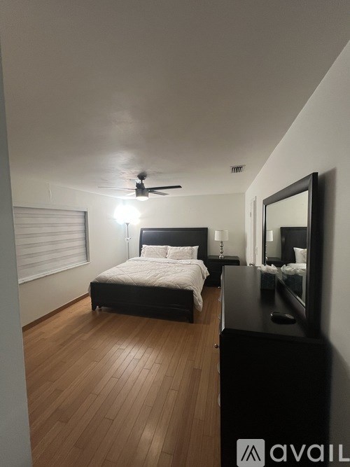 A bedroom with a bed, dresser, and mirror.