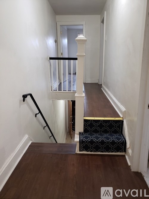 A hallway with a black and white patterned staircase.