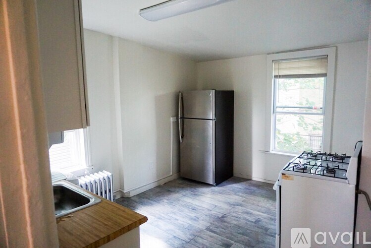 A kitchen with a stove, refrigerator, and sink.