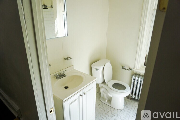 A white toilet sits next to a sink in a bathroom.