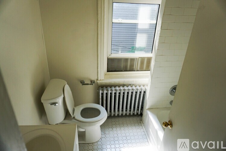 A white toilet and a toilet paper holder in a bathroom.