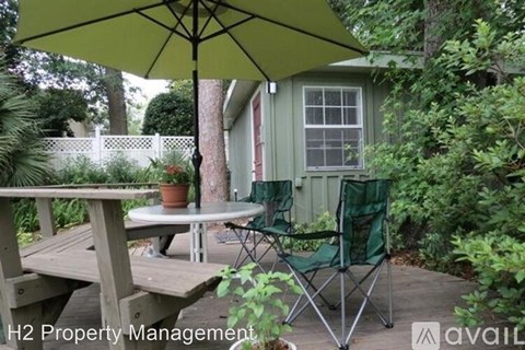 A patio with a table and chairs under an umbrella.