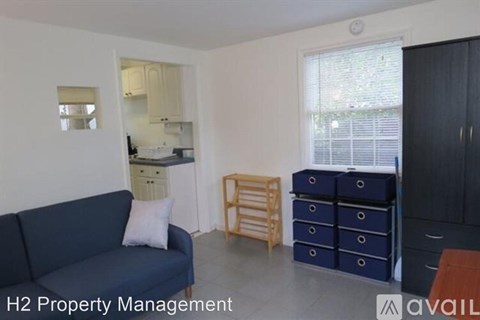 A living room with a blue couch and a cabinet with drawers.