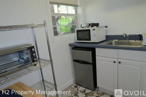 A kitchen with a microwave, oven, and sink.