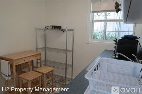 A kitchen area with a table, chairs, and a dishwasher.