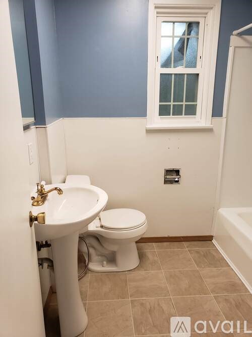 A bathroom with blue walls and a white toilet.