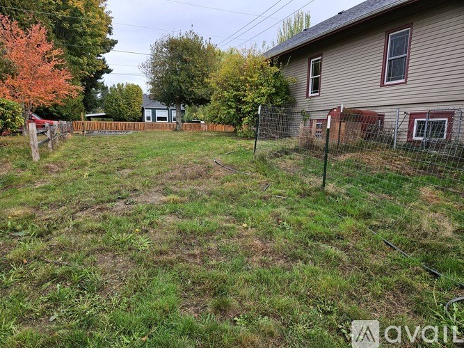 A backyard with a fence and a house in the background.