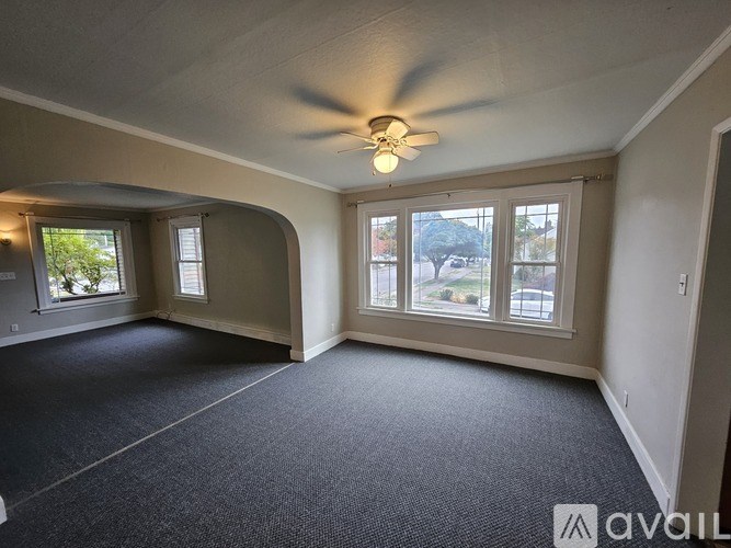 A room with a ceiling fan and carpeted floor.