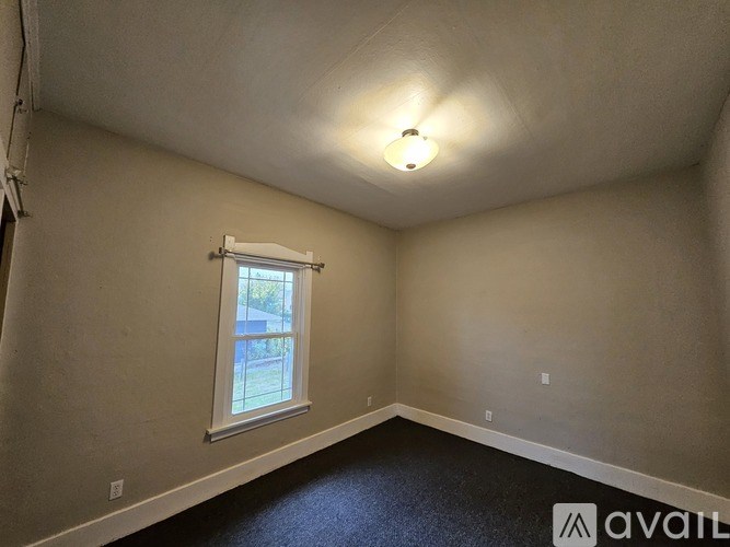 A room with a window and a light on the ceiling.