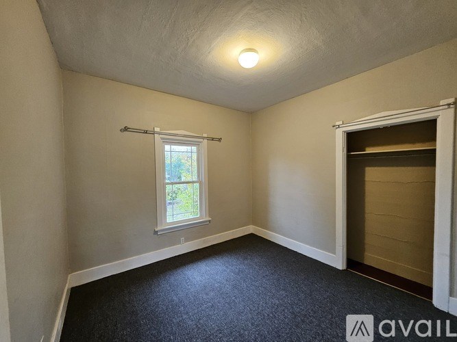 A room with a window and a door is available for rent.