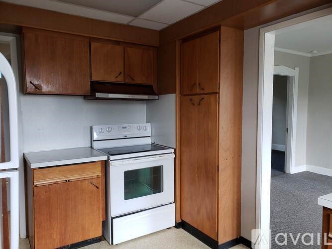 A kitchen with wooden cabinets and a white oven.