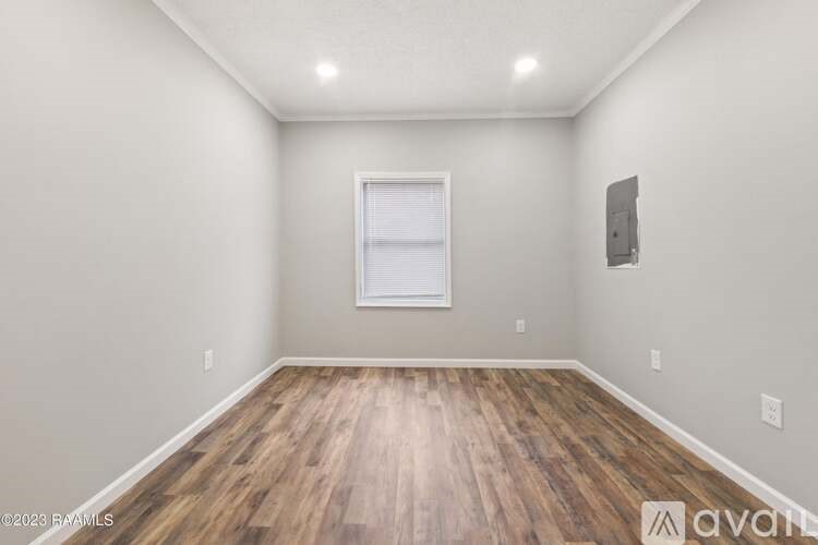 A room with wooden flooring and a window.