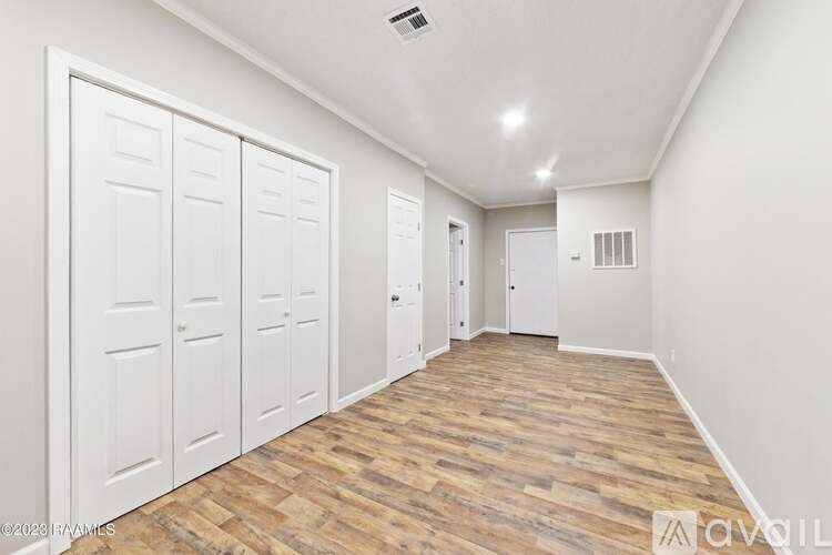 A room with white doors and wooden flooring.