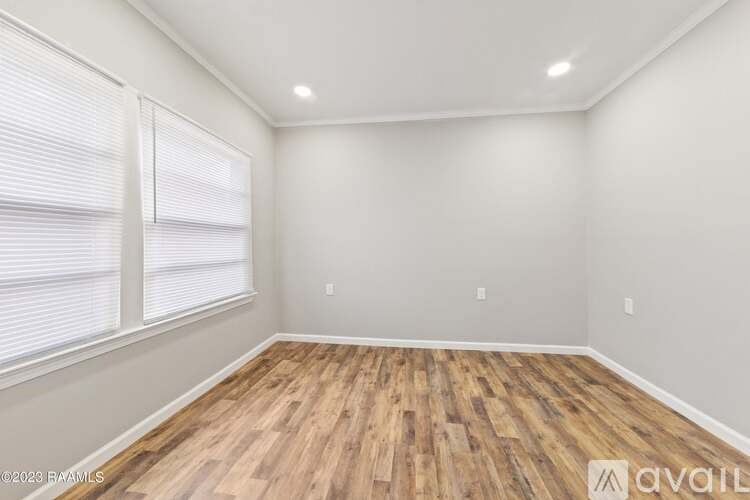 A room with wooden flooring and white walls.