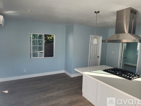 A kitchen with a stove top oven and a window.