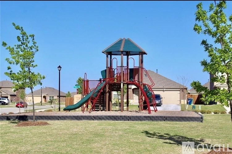 A playground with a red slide and a green roofed structure.