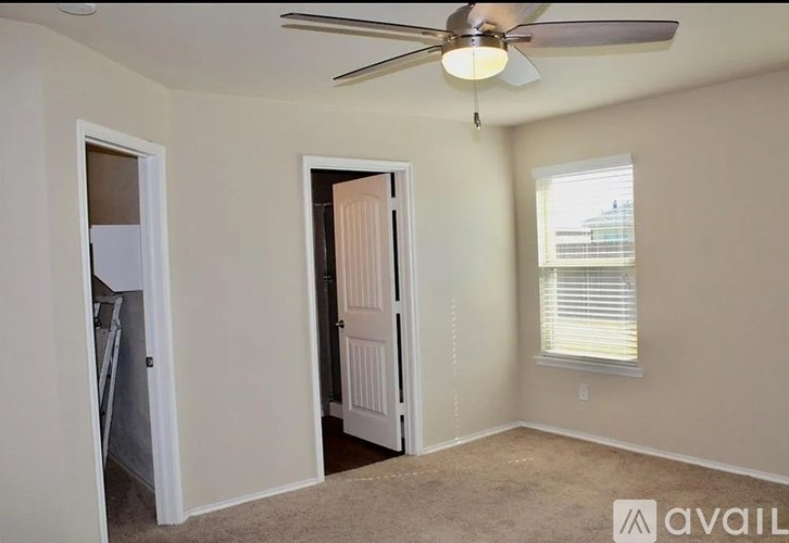 A room with a ceiling fan and two doors, one of which is open.