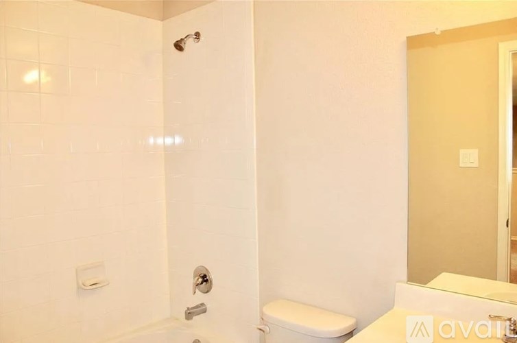 A bathroom with a toilet, a shower, and a sink.