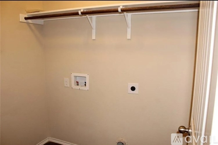 A white wall with a brown bar and two small square holes.