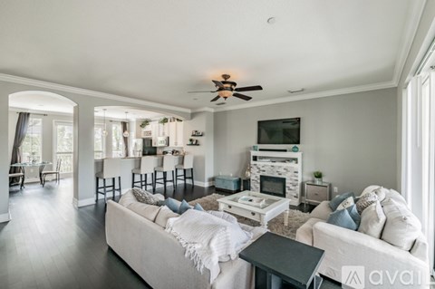 A living room with a white couch and a ceiling fan.