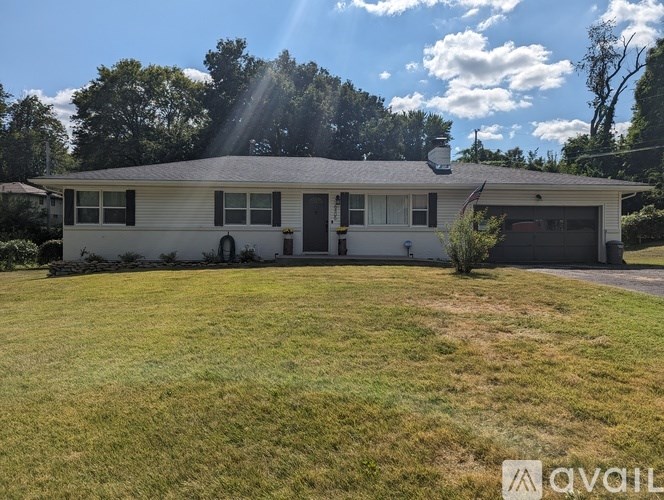 A house with a garage and a driveway is for sale.
