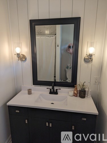 A bathroom vanity with a sink, mirror, and lights.