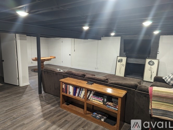 A room with a couch, a bookshelf, and a television.