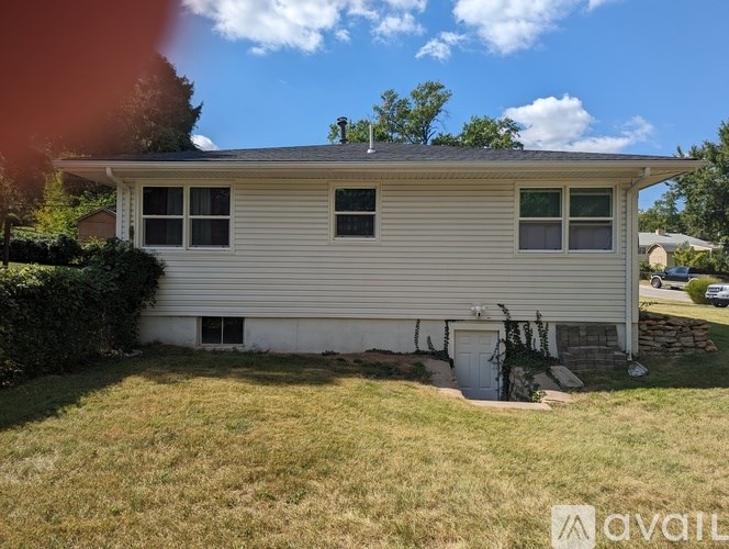 A house with a white siding and a grey roof is for sale.