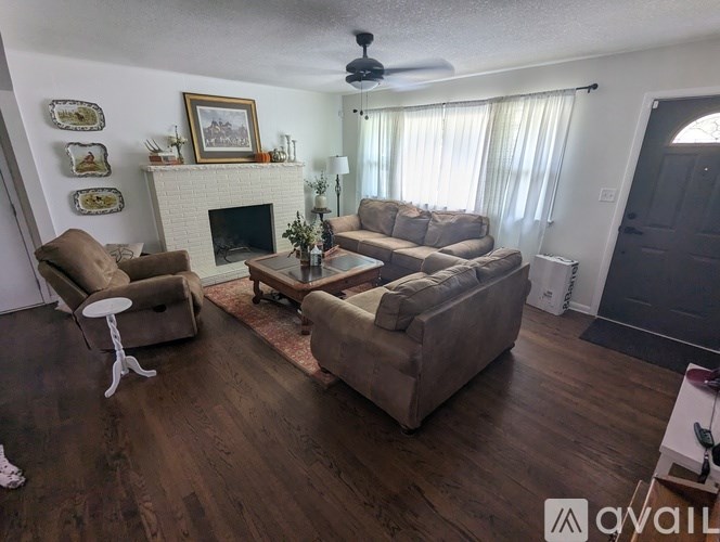 A living room with a fireplace, couches, and a rug.