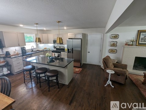 A kitchen with a bar stool and a chair in front of a counter.