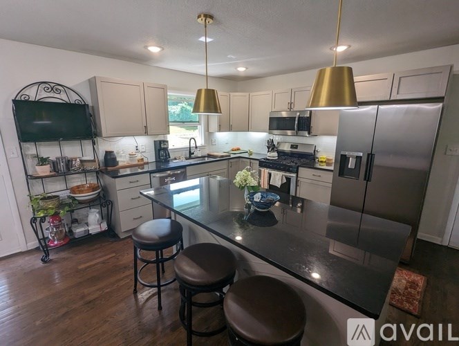 A kitchen with a black granite countertop and stainless steel appliances.