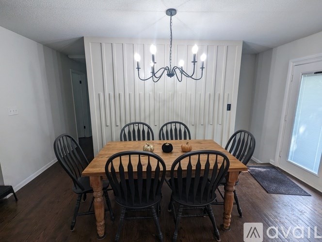 A dining room with a wooden table and chairs.