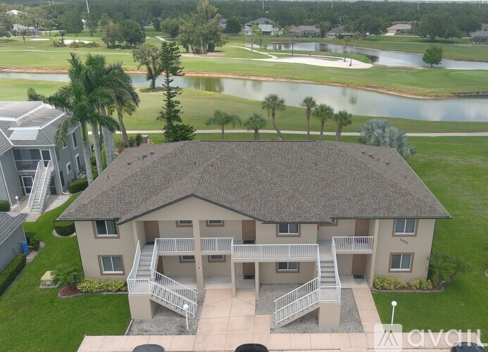 A house with a roof and a balcony is in the foreground of a golf course.