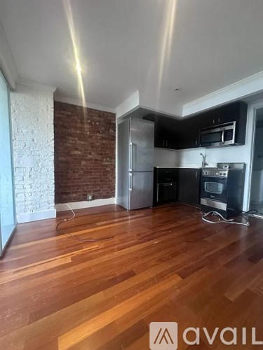 A kitchen with wooden floors and a brick wall.
